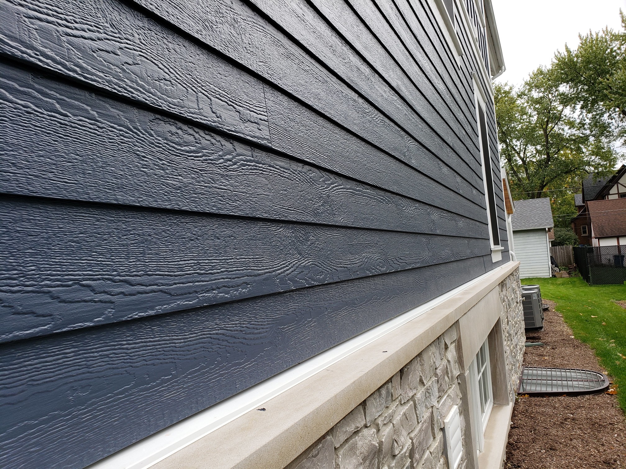 Dark blue LP siding on a suburban home.